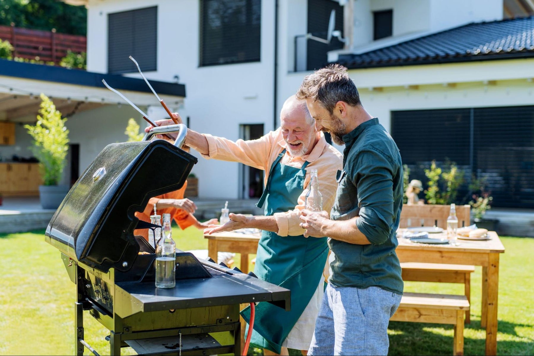 A father showing off the grill to their son